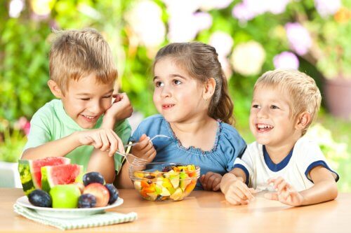 Enfants mangeant une salade de fruits, une idée de goûters sains et délicieux