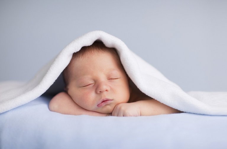 Bébé endormi sous une couverture