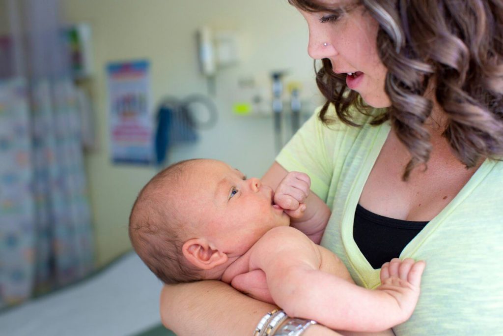 Maman qui chante à son bébé dans ses bras