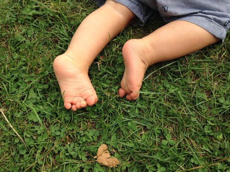 Pieds nus d'un bébé dans l'herbe 
