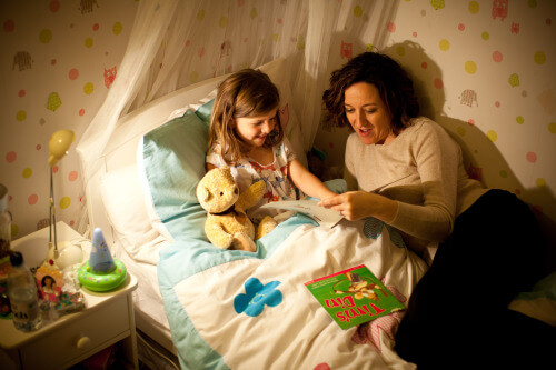 Maman en train de lire une histoire pour aider son enfant à dormir