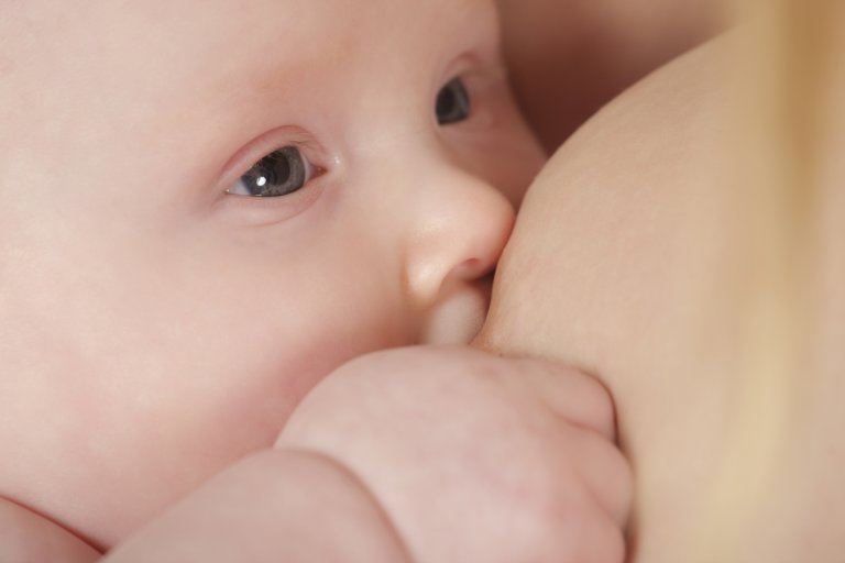 Bébé qui tète le sein de sa mère dans un moment de lien entre la mère et l'enfant