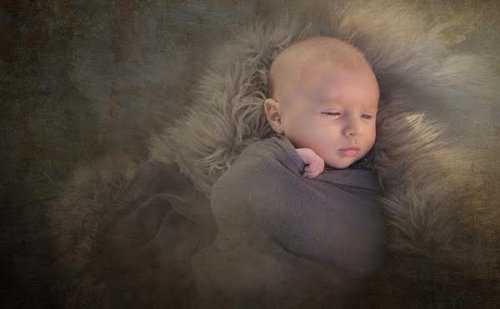 Bébé sans cheveux enveloppé dans une couverture