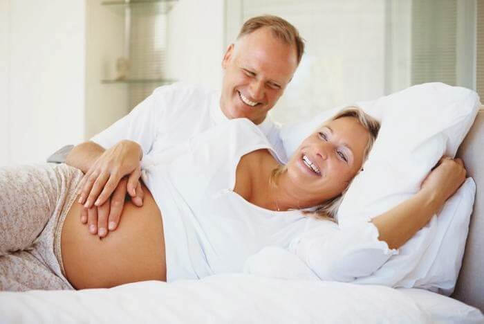 Une femme enceinte allongée sur le côté, une position pour bien dormir pendant la grossesse