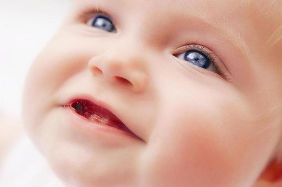 Bébé aux yeux bleus avec ses premières dents 