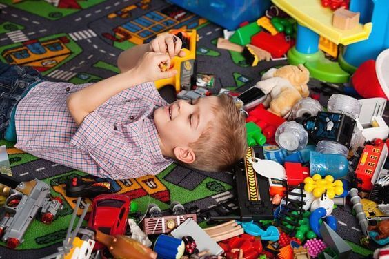 Enfant dans sa chambre avec beaucoup de jouets