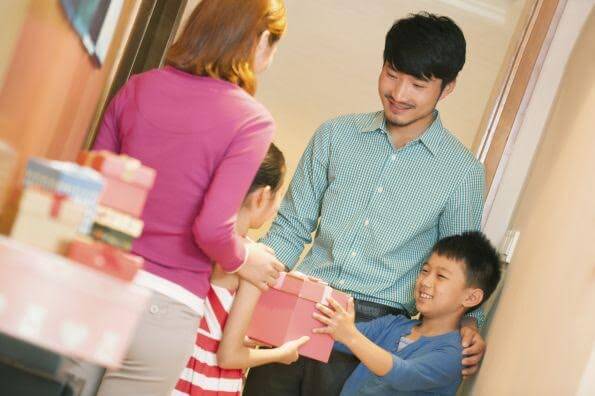 Enfant asiatique avec son père recevant chez lui une amie blanche avec sa mère