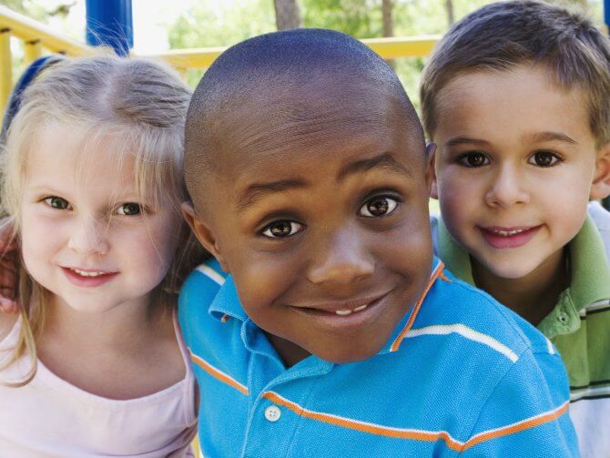 Enfant noir entouré d'enfants blancs