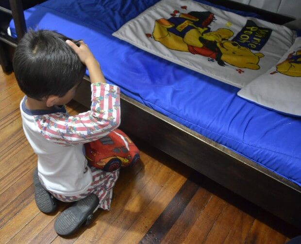 Enfant face à son lit mouillé après avoir fait pipi au lit