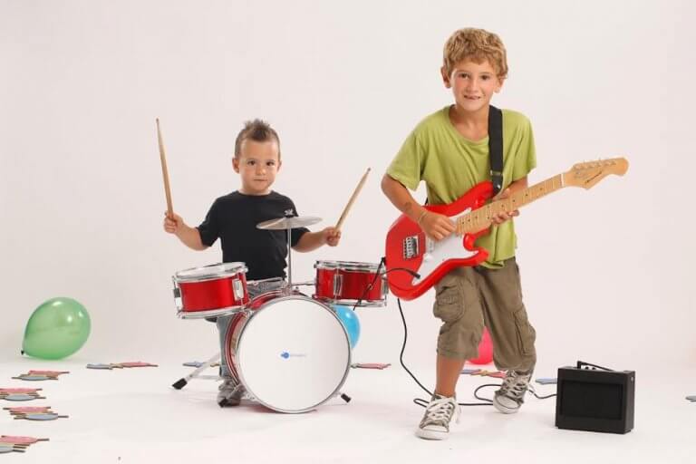 Enfants à la guitare et à la batterie, instruments dont l'apprentissage est bénéfique aux enfants