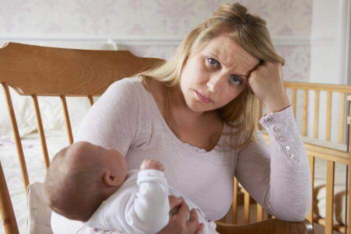 Maman contrariée avec son bébé dans ses bras qui se réveille la nuit 