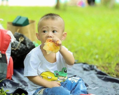 Un bébé mange dans un parc