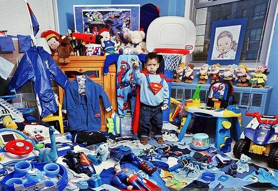 Enfant entouré de plein de jouets dans sa chambre, déguisé en Superman
