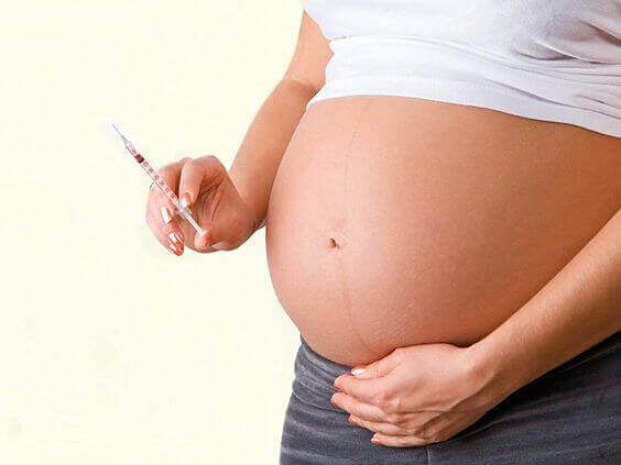 Une femme enceinte avec une seringue, traitement nécessaire lors d'un diabète gestationnel