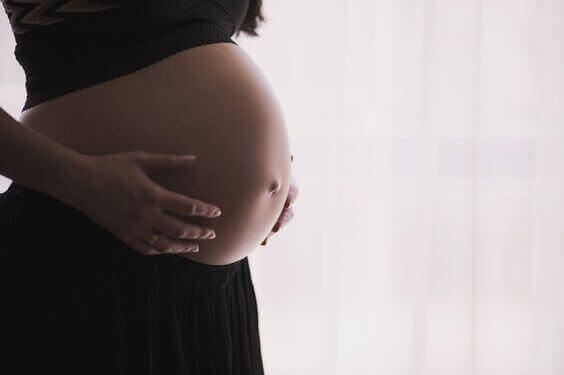Une femme enceinte avec les mains posées sur son ventre