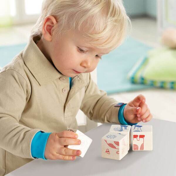 Un petit garçon de deux ans joue avec des cubes de bois