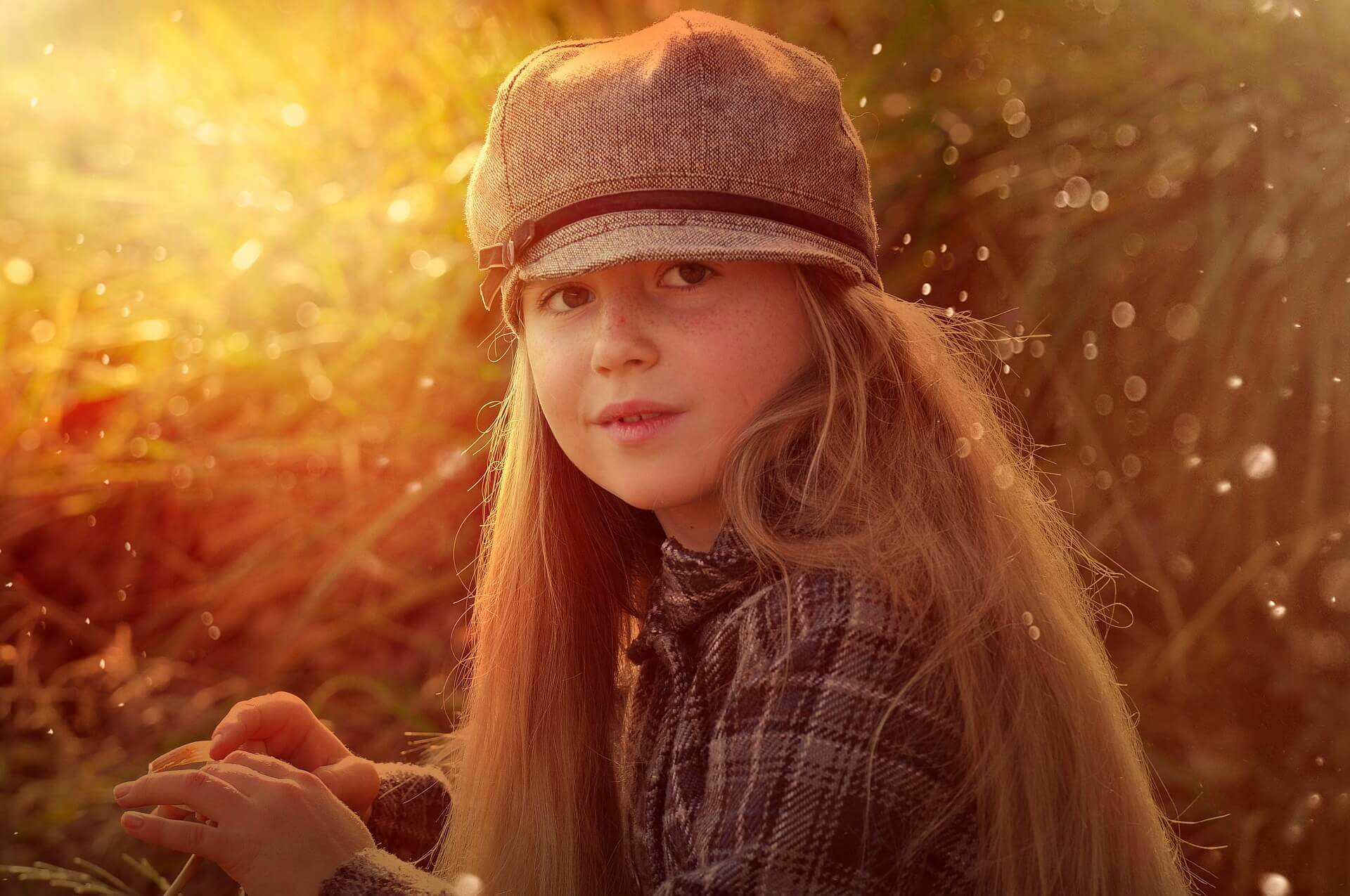 Une petite fille aux cheveux longs avec un béret