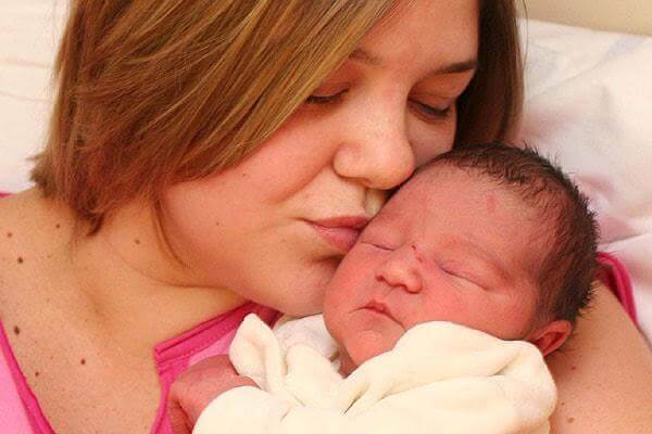 Nouveau né embrassé par sa maman