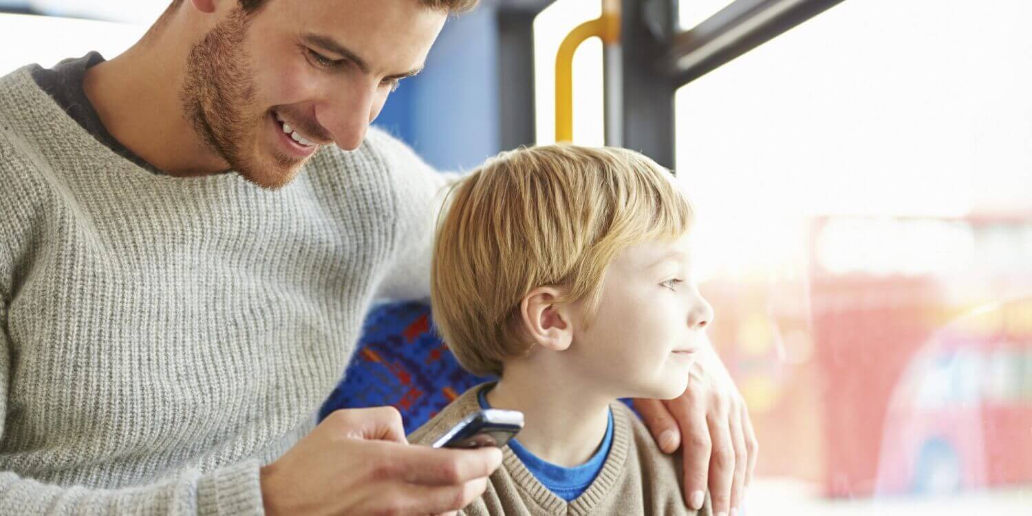Un père sur son téléphone dans le bus avec son fils