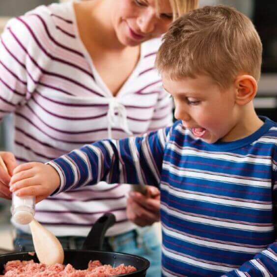 Un petit garçon cuisine avec sa maman 