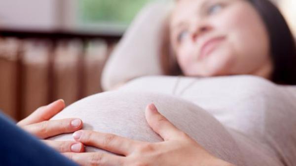 Femme enceinte couchée se tenant le ventre