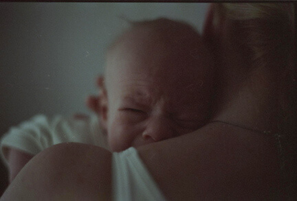 Un bébé en pleurs dans les bras de sa maman