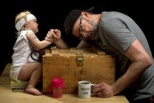 Un papa joue au bras de fer avec sa petite fille