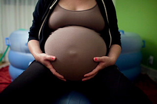 Une femme enceinte qui se tient le ventre