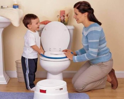 Une maman apprend à son enfant à aller sur le pot