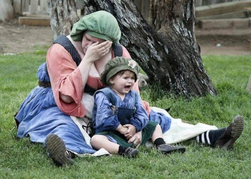 Une maman pleure avec son bébé dans les bras, un symptome du burn-out maternel