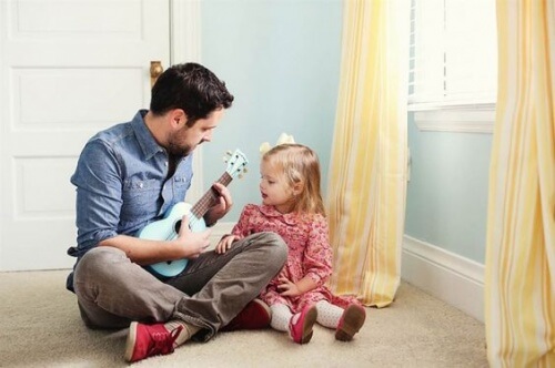 Un papa joue à la guitare avec sa petite fille, ce qui renforce la relation père-fille