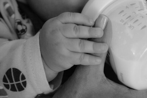 Un bébé boit du lait maternel au biberon, grâce à la mise en place d'une banque de lait par sa maman