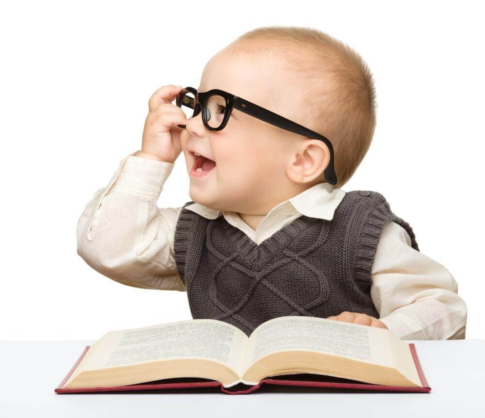 Un bébé avec des lunettes et un livre
