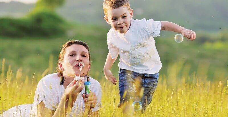 Une tante fait des bulles avec son neveu.