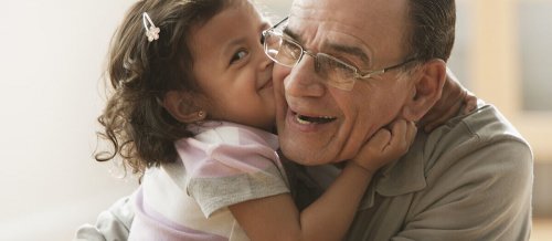 petite fille qui embrasse son grand-père