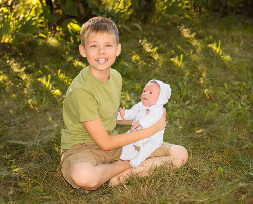 Grand frère qui tient sa petite soeur