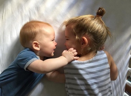 petite fille jouant avec son nouveau frère