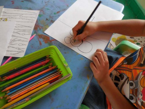 un enfant fait des dessins