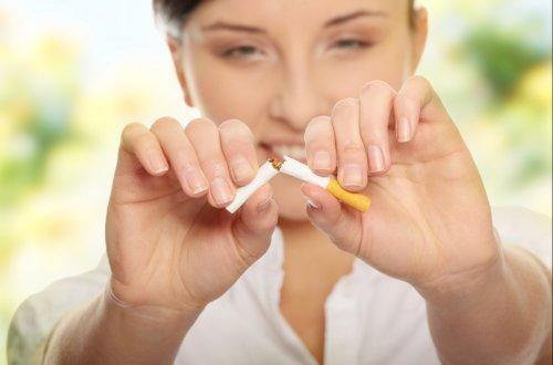 Une femme rompt une cigarette en deux