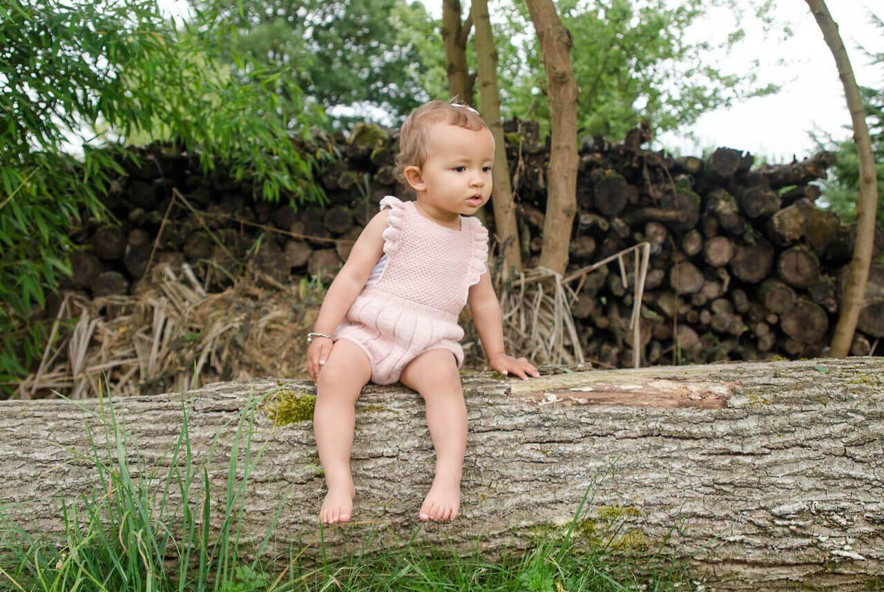 Un bébé est assis sur une branche