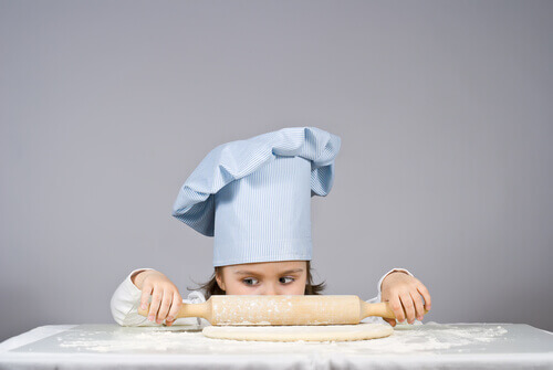 Une fille roule une pâte