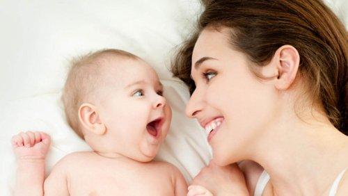 stimuler l'ouïe Une mère sourit à son bébé