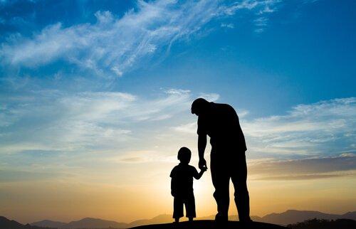 Un père et son fils devant un coucher de soleil