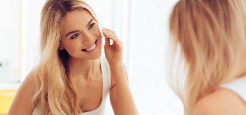 Une femme applique une crème hydratante