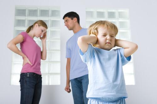 Un enfant se bouche les oreilles pour ne pas entendre les disputes de ses parents