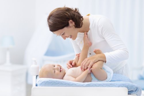 Une mère change son bébé