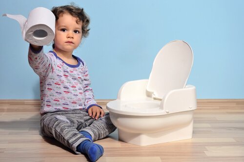 Un enfant assis à côté de son pot.