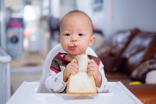Un bébé mange du pain
