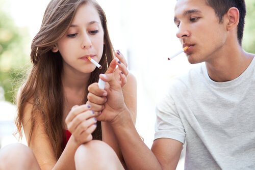 Un jeune allume la cigarette de son amie