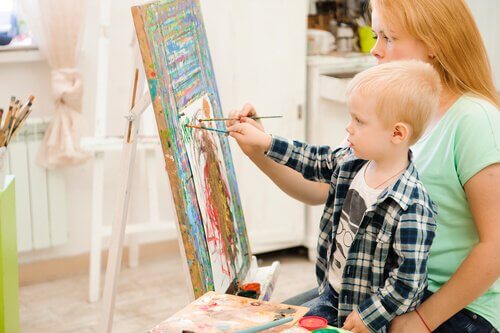 Un enfant en train de peindre avec sa mère